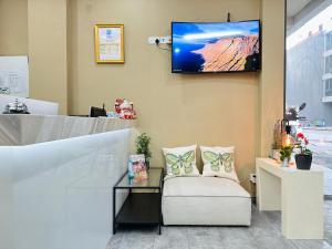 a waiting room with a chair and a tv on the wall at Snow Hotel Lavender in Singapore