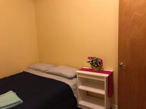 Habitación pequeña con cama y mesa con flores. en Room 2, en Chicago