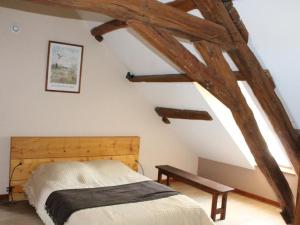 um quarto com uma cama num quarto com vigas de madeira em Gîte Douchy-Montcorbon-Douchy, 5 pièces, 7 personnes - FR-1-590-49 