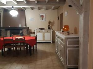 kuchnia i jadalnia z czerwonym stołem i krzesłami w obiekcie Gîte Douchy-Montcorbon-Douchy, 5 pièces, 7 personnes - FR-1-590-49 