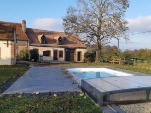 uma casa com piscina em frente a uma casa em Gîte Douchy-Montcorbon-Douchy, 5 pièces, 7 personnes - FR-1-590-49 