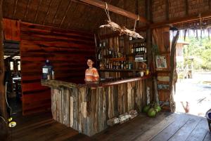 uma mulher atrás de um bar numa cabana em Lily's Riverhouse em Koh Rong Island