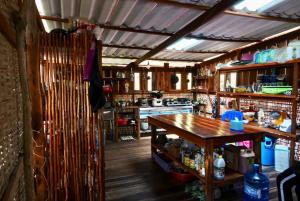 a kitchen with a wooden floor and a wooden table at Lily's Riverhouse in Koh Rong Island