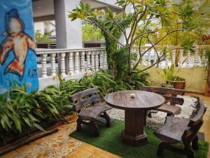 una mesa y dos bancos y una mesa y sillas en 3 Little Birds Home, 100meter to JonkerWalk, en Melaka
