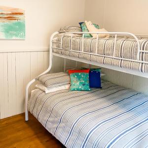 two bunk beds in a room with a bed at Nurture Creek in Monbulk
