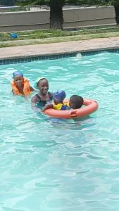 três crianças numa piscina numa piscina em myStay Sandton em Joanesburgo