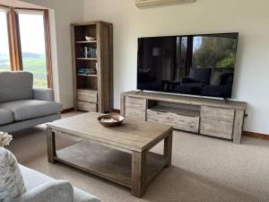 a living room with a television and a coffee table at Banksia in Port Campbell