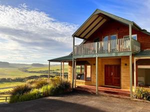a house with a balcony on top of it at Banksia in Port Campbell