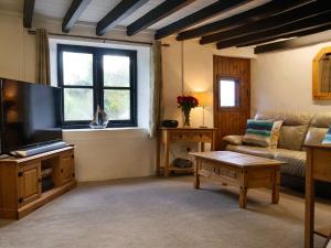 a living room with a couch and a flat screen tv at Easterly Cottage in Bude