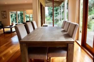 uma mesa de jantar com cadeiras e uma grande janela em Banksia em Port Campbell