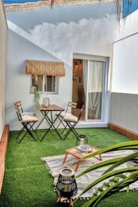 un patio con prato verde, tavolo e sedie di Suite con Jacuzzi en la montaña. a Pueblo Nuevo