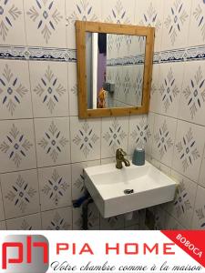 W łazience znajduje się umywalka i lustro. w obiekcie PIA HOME La Pompe w mieście Mamoudzou
