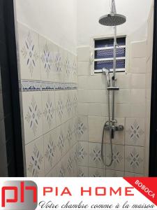 y baño con ducha y azulejos azules y blancos. en PIA HOME La Pompe en Mamoudzou