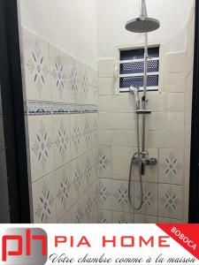 Łazienka z prysznicem wyłożona jest niebieskimi i białymi kafelkami. w obiekcie PIA HOME La Pompe w mieście Mamoudzou