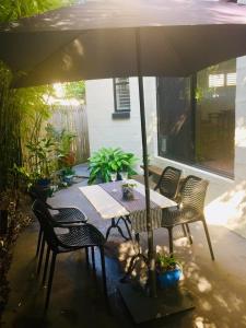 einen Tisch und Stühle unter einem Sonnenschirm auf einer Terrasse in der Unterkunft Swan Guest House in Brisbane