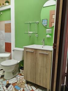a bathroom with a toilet and a sink and a mirror at Villa Gabriela, Casa Tucan in Liberia