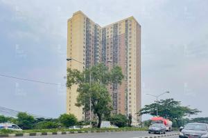 a tall building with a red truck in front of it at RedLiving Apartemen Tamansari Panoramic - Santuy Agency in Bandung