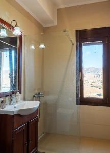 baño con lavabo y ducha con ventana en Seaview Villa en Tavari