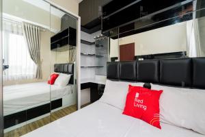 a bedroom with two beds and a mirror at RedLiving Apartemen Tamansari Panoramic - Santuy Agency in Bandung
