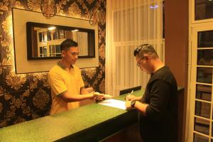 two men standing at a counter in a barber shop at Tree Love Temanggung Hotel in Parakan