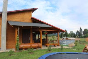 a log cabin with a porch with a large log bench at Chatka Pod Bukovkou in Červená Voda