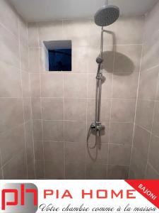 a shower with a shower head in a bathroom at PIA HOME Le Bajoni in Tsingoni