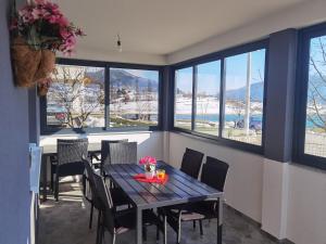 a dining room with a table and chairs and windows at Vikendica Bošnjak in Prozor