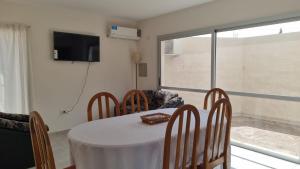 comedor con mesa, sillas y TV en Hermoso y moderno departamento a 10 cuadras de zona de bares en San Rafael Mendoza en San Rafael