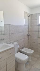 Baño blanco con aseo y lavamanos en Hermoso y moderno departamento a 10 cuadras de zona de bares en San Rafael Mendoza en San Rafael