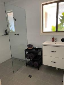 a bathroom with a shower and a table and a sink at Hardwicke Hideaway in Port Minlacowie