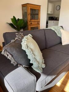 a gray couch with a pillow on top of it at Hardwicke Hideaway in Port Minlacowie