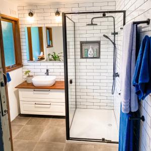 a bathroom with a shower and a sink at Nurture Creek in Monbulk