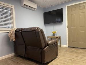 una silla reclinable de cuero marrón en una habitación con TV en Rejuvenation Cottage - Wine Country Tranquility, en Temecula
