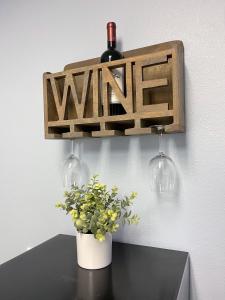 a bottle of wine and two glasses and a plant on a table at Rejuvenation Cottage - Wine Country Tranquility in Temecula