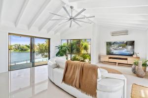 a living room with a white couch and a tv at Elite Holiday Homes Coobowie Waters in Gold Coast
