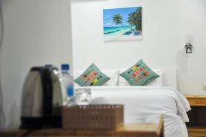 a bedroom with a bed with a phone and a picture at Asseyri Guest House in Maradhoofeydhoo