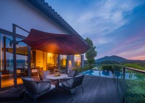 淳安的住宿－千岛湖安岚酒店，庭院配有桌椅和遮阳伞。