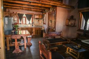 ein Wohnzimmer mit einem Tisch und einer Küche in der Unterkunft Cabaña Amanecer in Mazamitla