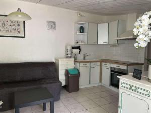a small kitchen with white cabinets and a couch at Maison Noirmoutier-en-l'Île, 3 pièces, 4 personnes - FR-1-224B-523 in Noirmoutier-en-l'lle
