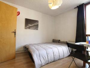 a bedroom with a bed and a table and a window at Studio à Serre-Chevalier avec Parking, Wifi et Local à Ski - FR-1-330E-65 in Serre Chevalier