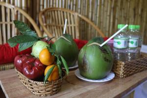 - une table avec des paniers de fruits et des bouteilles d'eau dans l'établissement Coco Island Cồn Phụng, à Ben Tre