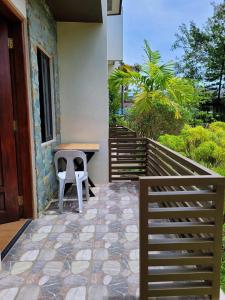 a porch with a bench and a table and stairs at La Belle Staycation in Puerto Princesa City