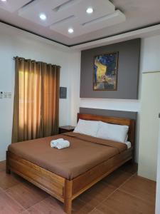 a bedroom with a bed with a towel on it at La Belle Staycation in Puerto Princesa City