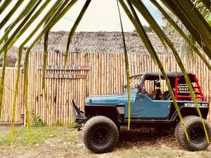 a blue jeep parked in front of a wooden fence at Nautilus Hostel & Hammocks in Panglao Island