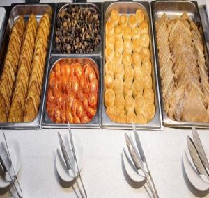 einen Tisch mit Tabletten verschiedener Arten von Lebensmitteln in der Unterkunft Asli Makon Hotel in Taschkent