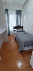- une chambre avec un lit et du parquet dans l'établissement SCANDIA SUITES AT SOUTH FORBES Homey & Cozy 2-Bedroom Condo, à Silang