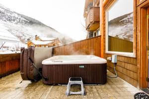 a hot tub on a balcony with a snow covered mountain at Mountain Chalet in Girdwood