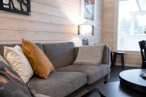 - un salon avec un canapé et des oreillers dans l'établissement Holiday in Lapland - Levihovi 6B, à Levi 18 autres photos