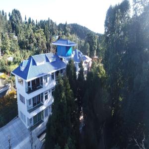 an aerial view of a house with a blue roof at Amaira Resort & Farms - Mirik, West Bengal in Mirik