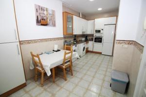 eine Küche mit Tisch und Stühlen und einem Kühlschrank in der Unterkunft Madrid, C. Mayor in Madrid